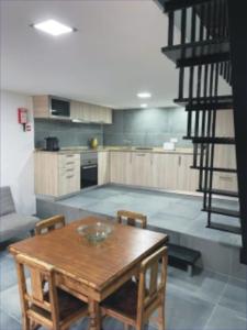 a kitchen with a wooden table and chairs and a staircase at Casa Sofia in Vila Pouca de Aguiar