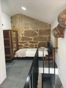 a bedroom with a bed and a stone wall at Casa Sofia in Vila Pouca de Aguiar