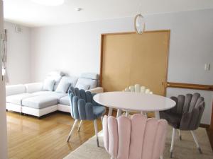 函馆安娜贝尔公寓的客厅里有一张沙发、一张桌子和几把椅子。