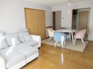 a living room with a white couch and a table at Guest House Annabel in Hakodate