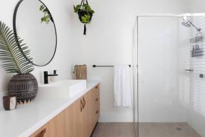 a bathroom with a sink and a mirror at Currumbin Sanctuary Beach Abode in Gold Coast