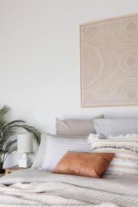 a white bedroom with a bed with a pillow on it at Currumbin Sanctuary Beach Abode in Gold Coast