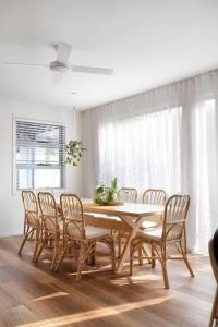 a dining room with a wooden table and chairs at Currumbin Sanctuary Beach Abode in Gold Coast