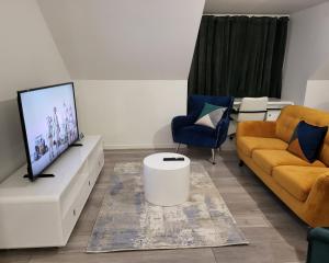 a living room with two couches and a flat screen tv at Garland Modern 2 Bedroom Apartment With Parking London in Plumstead