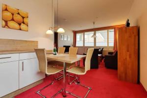 een keuken en eetkamer met een tafel en stoelen bij Ferienwohnung-48-mit-Meerblick-Residenz-Meeresbrandung-Duhnen in Cuxhaven