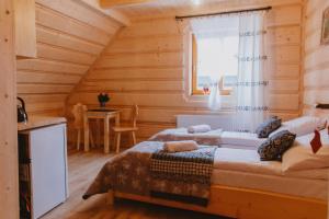 a bedroom with a bed in a log cabin at Drewniane Izby Pilchówka in Chochołów