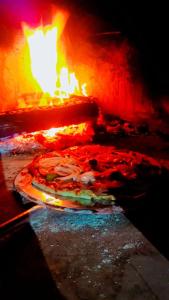 Uma pizza está a ser cozinhada num forno a lenha. em Casa de praia cantinho do Saco 12 pessoas em Angra dos Reis