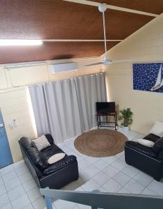 a living room with two leather couches and a rug at Emthree Seaside Apartments in Townsville