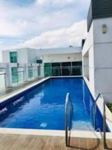 Suite exclusiva con balcón y maravillosa vista في غواياكيل: مسبح ازرق كبير بجانب مبنى