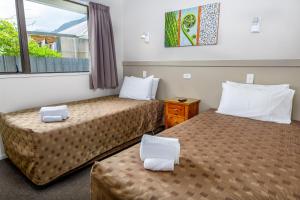 um quarto de hotel com duas camas e uma janela em The Terrace em Franz Josef