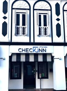 a black and white building with a sign for a checkenum at Check-Inn at Little India in Singapore