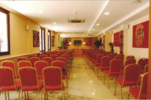 una sala conferenze con sedie rosse in una stanza di Hotel Ara Solis a Lido Azzurro