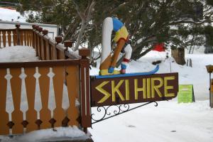a sign with a statue of a snowboard on it at Hotel Pension Grimus in Mount Buller