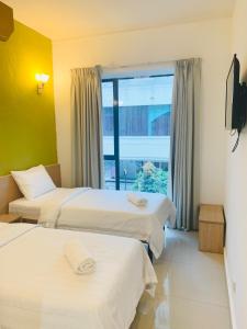 a hotel room with two beds and a window at Bintang Garden Hotel in Kuala Lumpur