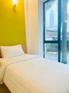 um quarto com uma cama branca e uma janela em Bintang Garden Hotel em Kuala Lumpur