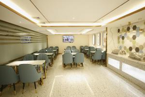 - une salle de conférence avec des chaises, des tables et une télévision dans l'établissement 银座佳驿酒店（郓城汽车站店）, à Yuncheng