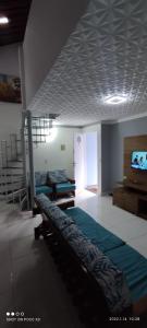 a room with two beds and a television and a staircase at Casa de condomínio para 6 pessoas, tudo a pé, perto do centro e piscinas naturais in Porto De Galinhas