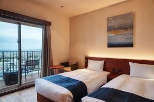 宜野灣的住宿－THE GRAND HOTEL GINOWAN，酒店客房设有两张床和一个阳台。