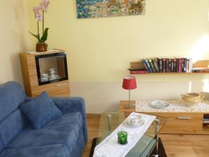 a living room with a blue couch and a table at Moselferienhaus-Zeltingen in Zeltingen-Rachtig