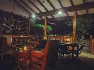 a restaurant with tables and chairs at night at Finca Queveri in Orosí