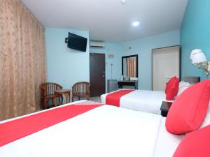 Cette chambre d'hôtel comprend 2 lits avec des oreillers rouges. dans l'établissement Marjan Hotel Sdn Bhd, à Cukai