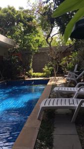 a swimming pool with two white chairs next to it at Nature Home in Phra Nakhon Si Ayutthaya