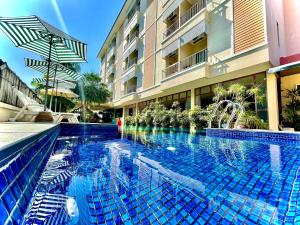 a swimming pool in front of a building at Smile Hua-Hin Resort - SHA Plus in Hua Hin