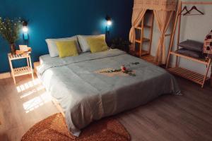 a bedroom with a large bed with a blue wall at Coucou Homestead I - Homestay & Dorm District 1 in Ho Chi Minh City