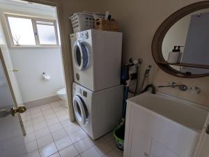 a kitchen with a washer and dryer on a refrigerator at Sunset on Birubi pet friendly air con water views WI-FI and outdoor spa in Anna Bay