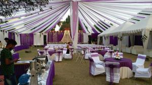 a marquee with purple and white tables and chairs at Holiday Home Ranchi in Rānchī