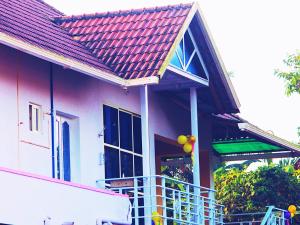 a house with a red roof and a balcony with balloons at Hiremane Residency in Sringeri