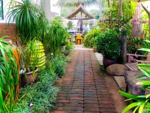 a brick path in a garden with plants at Smile Hua-Hin Resort - SHA Plus in Hua Hin