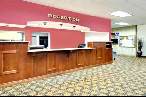a reception area of a hospital with a red wall at Norwood Inn & Suites Worthington in Worthington