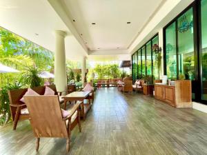 a restaurant with tables and chairs and windows at Smile Hua-Hin Resort - SHA Plus in Hua Hin