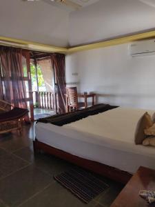 a bedroom with a large bed in a room at Mariposa Beach Grove in Agonda