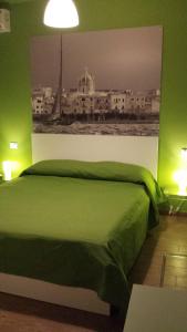 a green bedroom with a bed with a picture on the wall at Casa Magistrale in Trapani