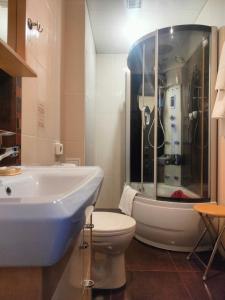 a bathroom with a sink and a toilet and a shower at Turmalin guest rooms in Loo