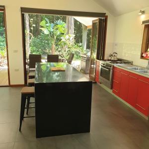 une grande cuisine avec des placards rouges et un comptoir dans l'établissement Forest views, à Diwan