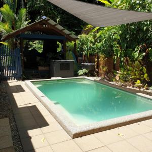 una piscina en un patio con sombrilla en Forest views en Diwan