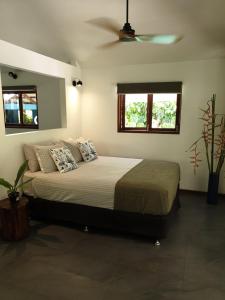 um quarto com uma cama e uma ventoinha de tecto em Forest views em Diwan