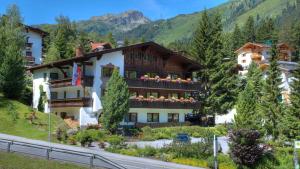 a hotel in the mountains with flowers on the balcony at Appartements Kohlereck in Sankt Anton am Arlberg