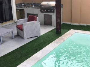 - un salon avec une piscine d'herbe verte dans l'établissement LUXURIOUS 3 BEDROOM HOUSE IN GOLD COAST, à Palm-Eagle Beach