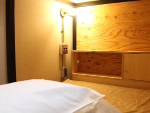a bedroom with a bed with a light on it at Guesthouse ushiyado in Naka-shibetsu