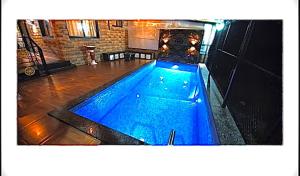 a swimming pool with blue water and a fireplace at Mount bungalows-Mount cottage-wifi-pvt pool in Lonavala