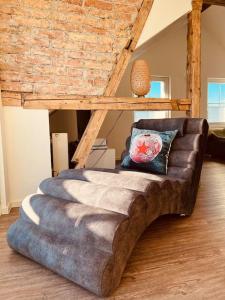um sofá de couro numa sala de estar com uma parede de tijolos em Penthouse im Dachgeschoss em Sonthofen