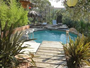 una piscina con una pasarela de madera en un patio en SIANDAKI NID D AMOUR AVEC JACUZZI, en La Motte