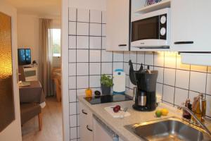 a kitchen with a sink and a microwave at Landhaus Lippmann Whg2 in Grönwohldshorst