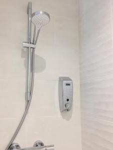 La salle de bains est pourvue d'une douche avec un pommeau de douche. dans l'établissement Grand Studio avec terrasse proche de l'hypercentre de Lorient, à Lorient