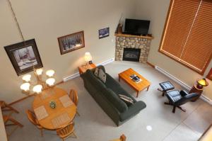 een woonkamer met een bank, een tafel en een open haard bij Apartment 405 Bear Creek Crossing in Canmore