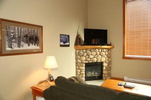een woonkamer met een bank en een open haard bij Apartment 405 Bear Creek Crossing in Canmore +6 foto's